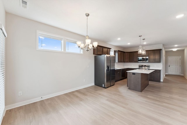 kitchen with baseboards, dark brown cabinetry, stainless steel appliances, and light countertops