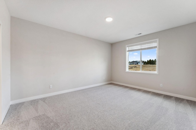 carpeted spare room featuring baseboards, recessed lighting, and visible vents