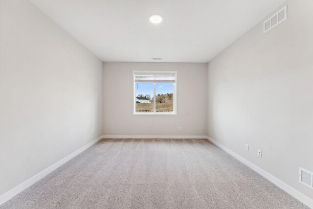 unfurnished room featuring visible vents, baseboards, and light carpet