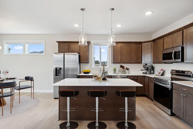1332 Rose St, New Richmond, WI 54017 - kitchen featuring appliances with stainless steel finishes, light wood-style floors, a center island, light countertops, and recessed lighting