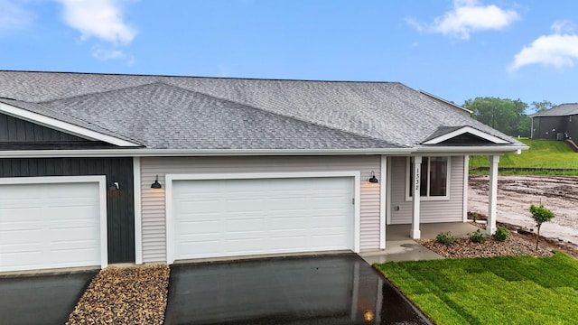 1332 Rose St, New Richmond, WI 54017 - view of front of property featuring roof with shingles, driveway, a garage, and covered porch