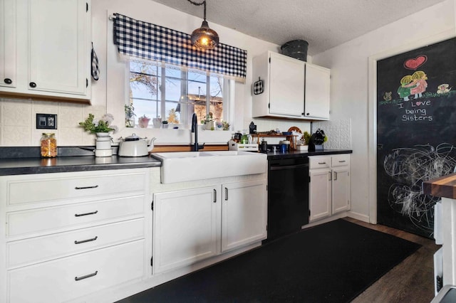 kitchen with a sink, dark countertops, dishwasher, and white cabinets