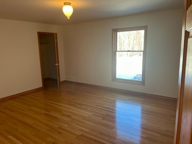 spare room with light wood-style flooring and baseboards