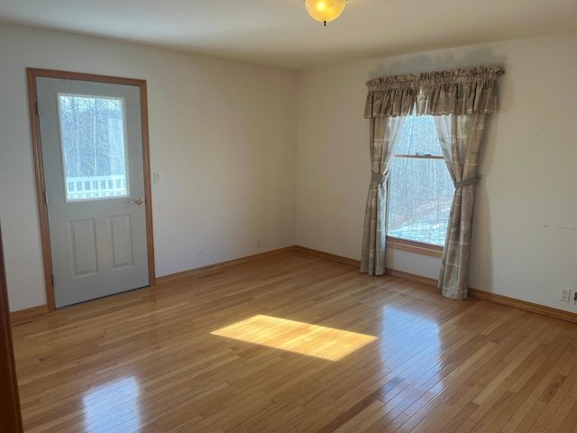 unfurnished room featuring light wood-style flooring and baseboards