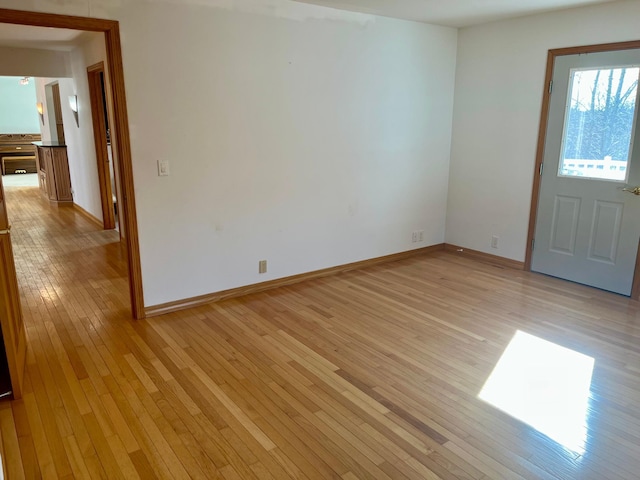 empty room with baseboards and light wood-style floors