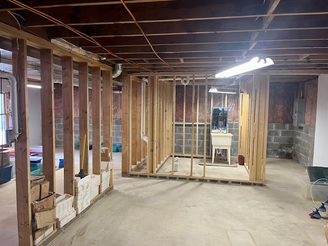 unfinished basement with electric panel and a sink