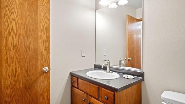 half bathroom featuring toilet and vanity