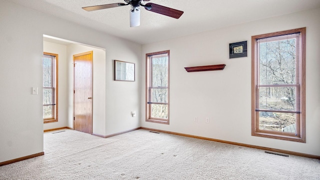 empty room with visible vents, baseboards, carpet, and a textured ceiling