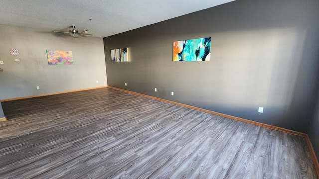 spare room featuring a textured ceiling, baseboards, a ceiling fan, and wood finished floors