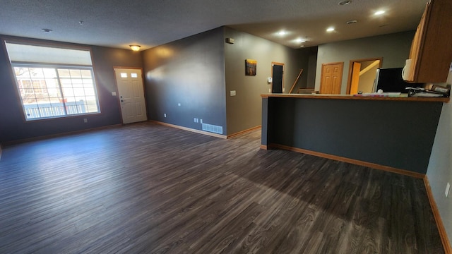 interior space featuring visible vents, baseboards, dark wood finished floors, recessed lighting, and a textured ceiling