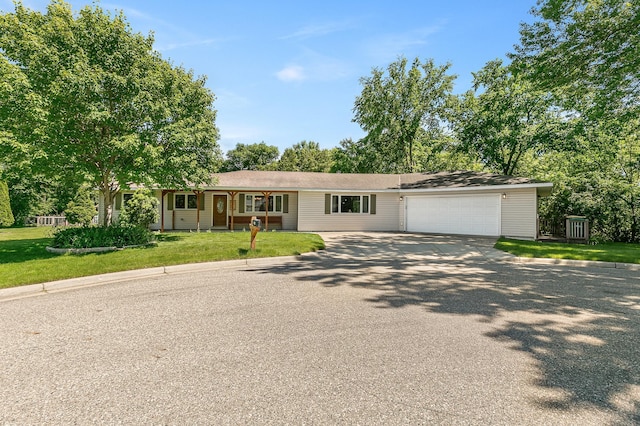 ranch-style home with a front lawn, an attached garage, and concrete driveway