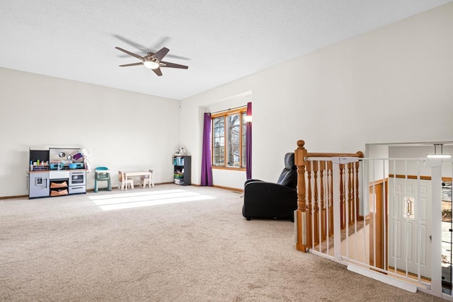 playroom with baseboards, carpet, a ceiling fan, and a textured ceiling