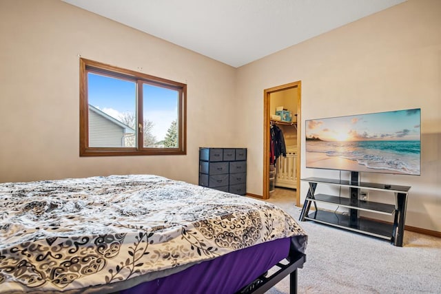 carpeted bedroom with a walk in closet, baseboards, and a closet