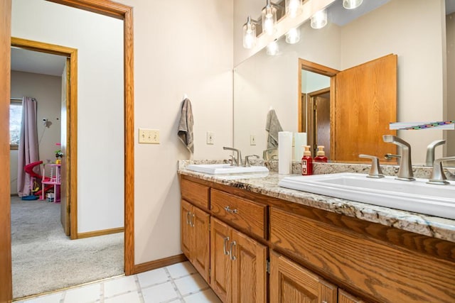 full bathroom featuring tile patterned floors, double vanity, baseboards, and a sink