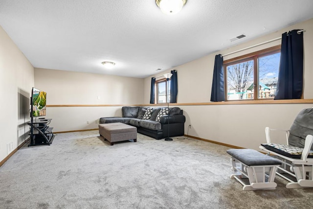 living area featuring baseboards, carpet, visible vents, and a textured ceiling