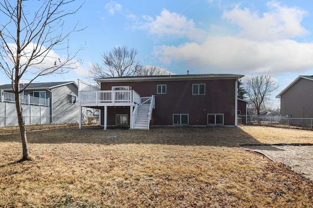 back of property with a wooden deck, stairs, a yard, and fence