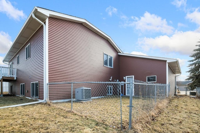 view of side of property featuring central AC unit, a lawn, and fence