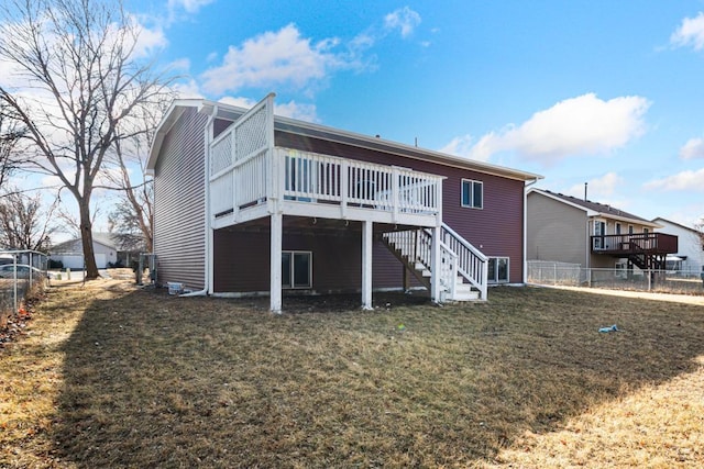 back of house featuring stairway, a wooden deck, a yard, and fence