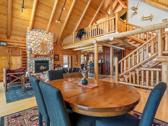 dining room with hardwood / wood-style floors, stairway, wooden ceiling, and a fireplace