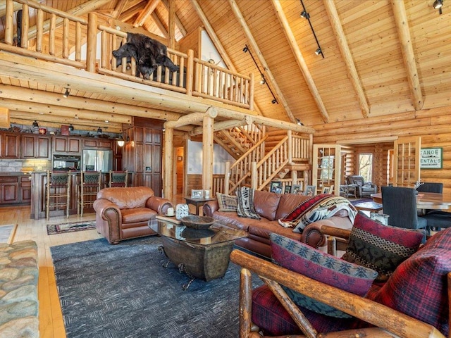 living room featuring beam ceiling, wood ceiling, stairs, and light wood-style floors