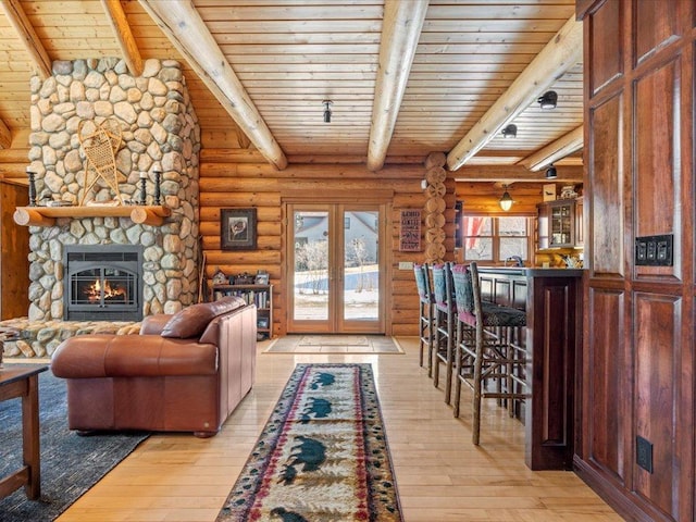 living area with light wood-type flooring, beam ceiling, rustic walls, french doors, and wooden ceiling