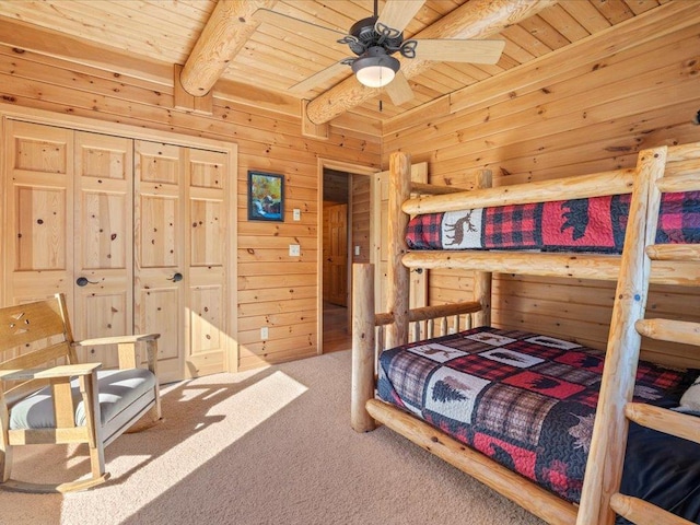 bedroom featuring beamed ceiling, wooden walls, wooden ceiling, and carpet