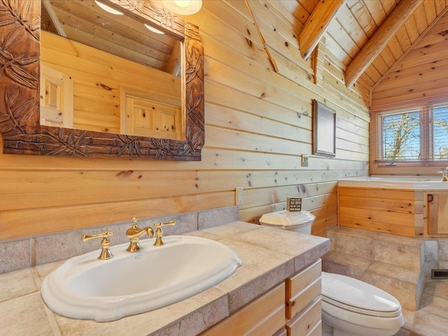 bathroom with vaulted ceiling with beams, wood walls, toilet, wooden ceiling, and vanity