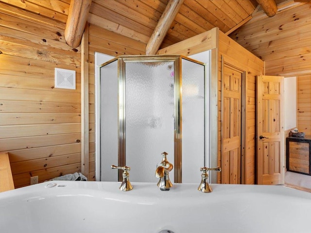 full bath with wooden walls, a shower stall, wood ceiling, lofted ceiling with beams, and a sink