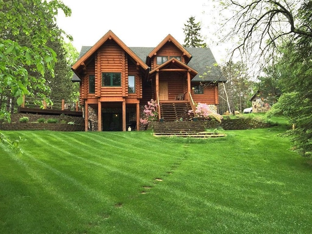 rear view of property featuring a lawn, log exterior, and stairs