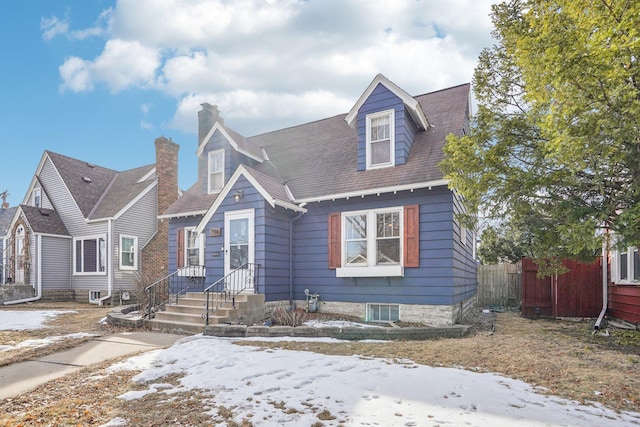 view of front of house featuring a chimney and fence