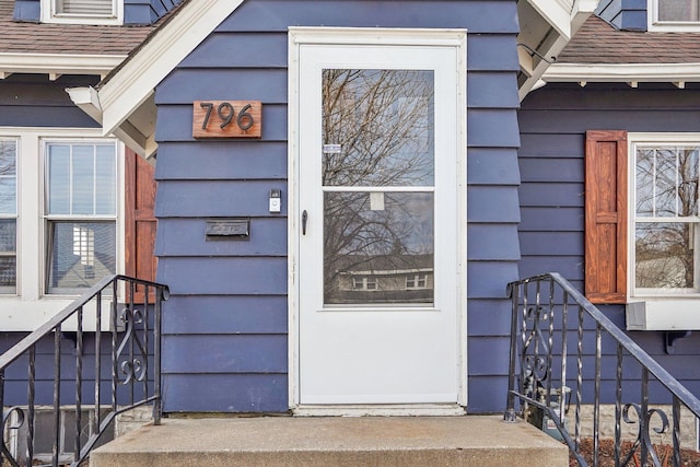 entrance to property with roof with shingles