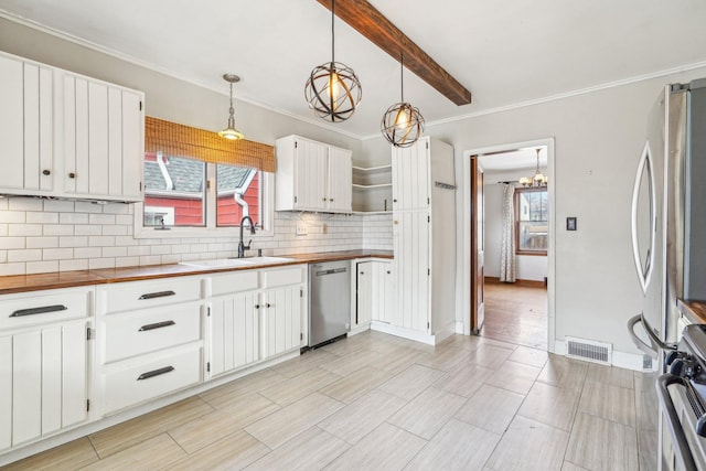 kitchen featuring visible vents, butcher block counters, a notable chandelier, stainless steel appliances, and a sink