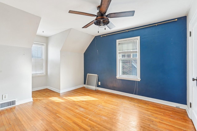 bonus room featuring visible vents, baseboards, ceiling fan, vaulted ceiling, and wood-type flooring