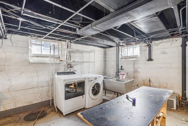 clothes washing area featuring washer and clothes dryer, laundry area, and a sink