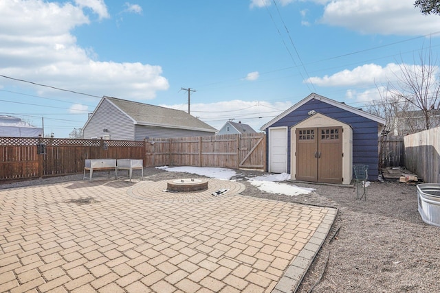 exterior space featuring a fire pit, a fenced backyard, a storage shed, and an outdoor structure