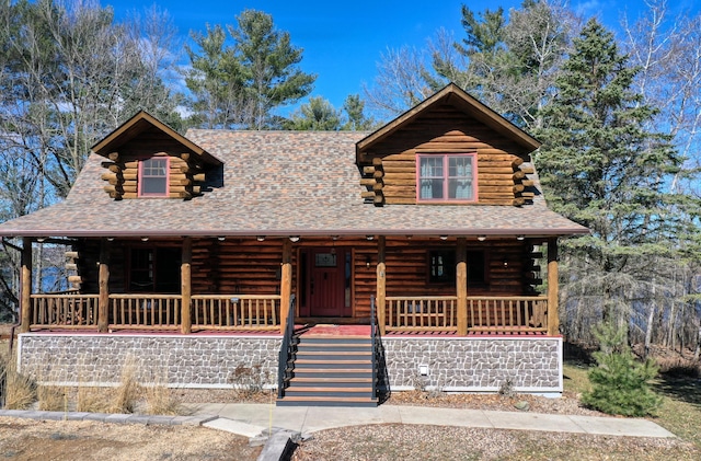 log home featuring log siding and covered porch