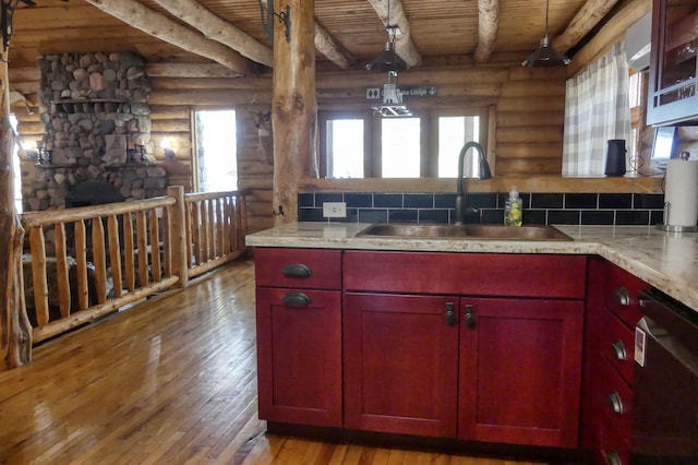 kitchen with decorative backsplash, dishwashing machine, wood ceiling, and a sink