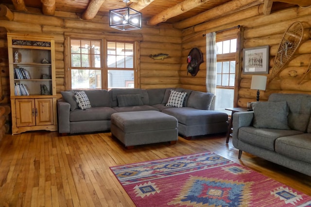 living area with light wood-style flooring, a notable chandelier, wood ceiling, and beamed ceiling