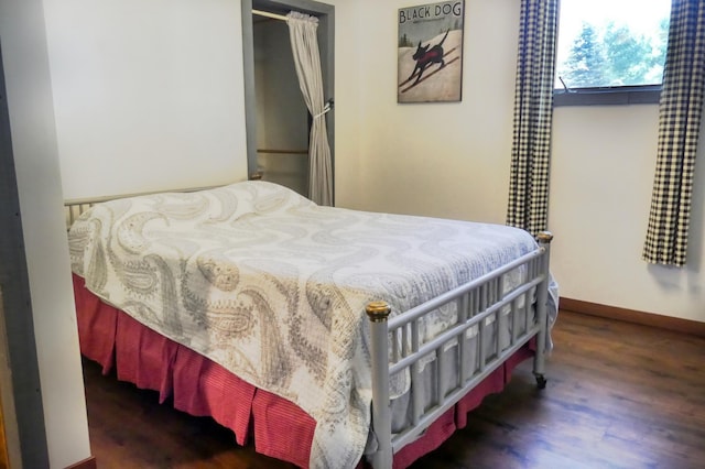 bedroom featuring baseboards and wood finished floors