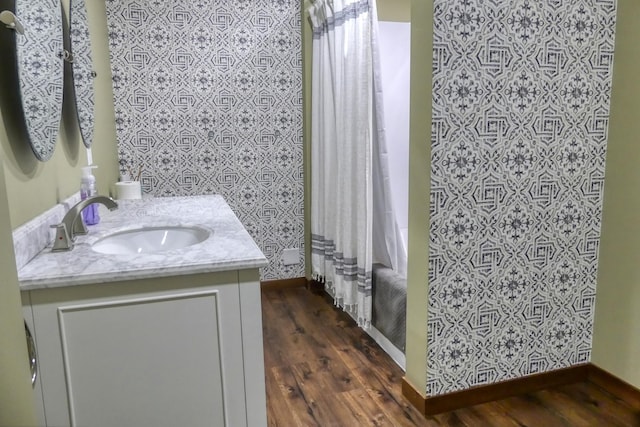 bathroom with shower / bath combination with curtain, vanity, baseboards, and wood finished floors