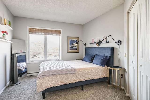 bedroom with a textured ceiling, a closet, baseboard heating, and carpet