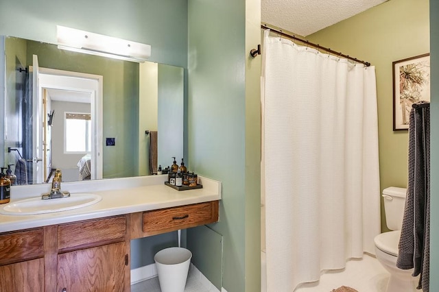 bathroom with vanity, ensuite bath, toilet, and a textured ceiling