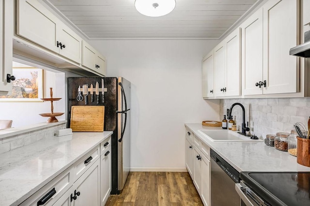 kitchen featuring tasteful backsplash, white cabinetry, stainless steel appliances, and a sink