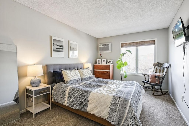 bedroom featuring carpet floors, a textured ceiling, baseboards, and a wall mounted air conditioner