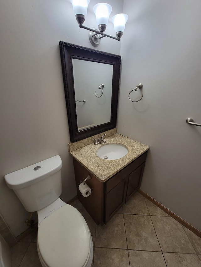 bathroom with tile patterned floors, toilet, baseboards, a chandelier, and vanity