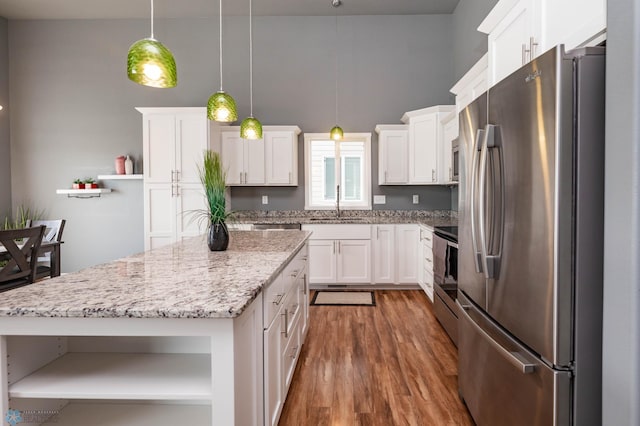 kitchen with open shelves, appliances with stainless steel finishes, wood finished floors, white cabinets, and a sink