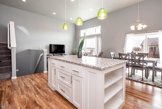 kitchen with light wood-style flooring, pendant lighting, white cabinetry, and open shelves