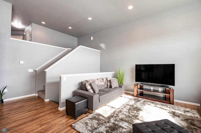 living area with recessed lighting, stairs, baseboards, and wood finished floors