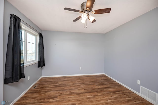 unfurnished room featuring ceiling fan, visible vents, baseboards, and wood finished floors