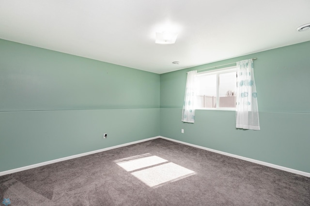 spare room with baseboards and carpet floors